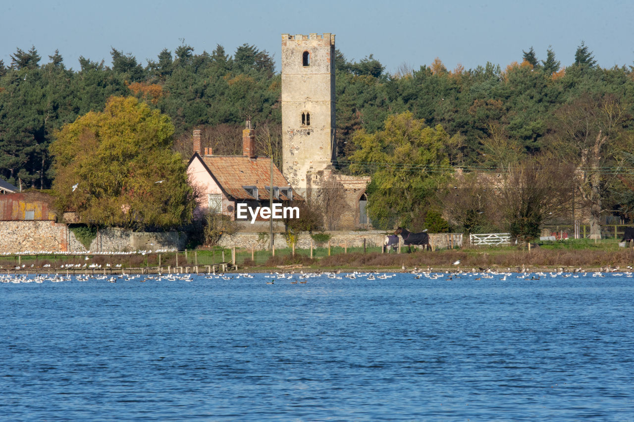 BUILT STRUCTURE BY LAKE AGAINST SKY