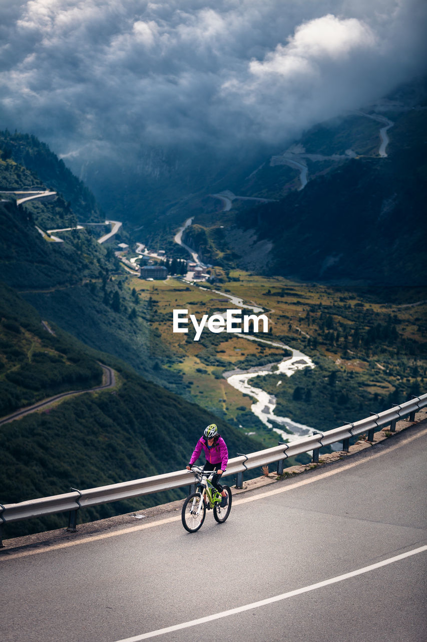 Woman riding bicycle on mountain road