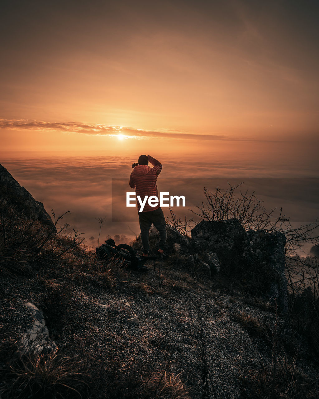 MAN PHOTOGRAPHING ORANGE SKY