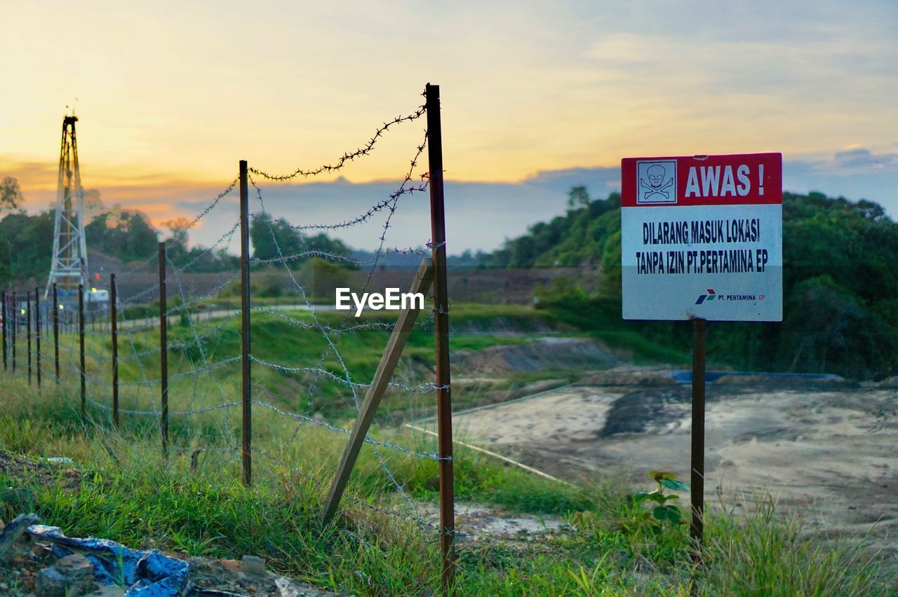 Information sign on field against sky