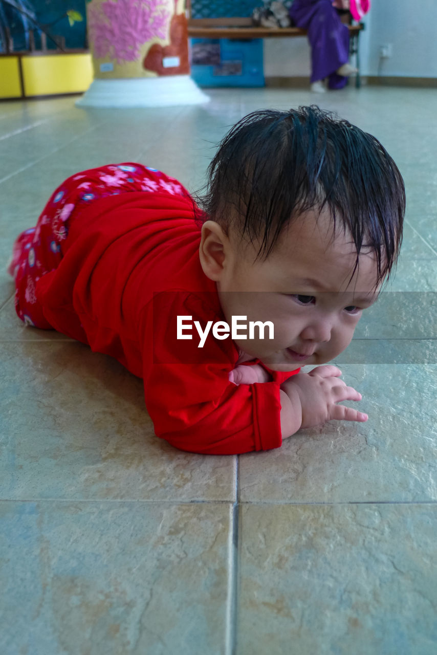 Close-up of toddler lying on floor