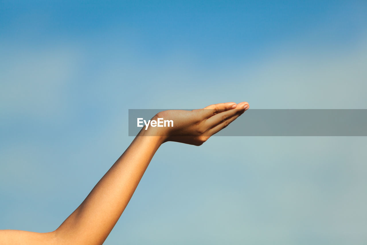 Cropped image of woman gesturing against sky