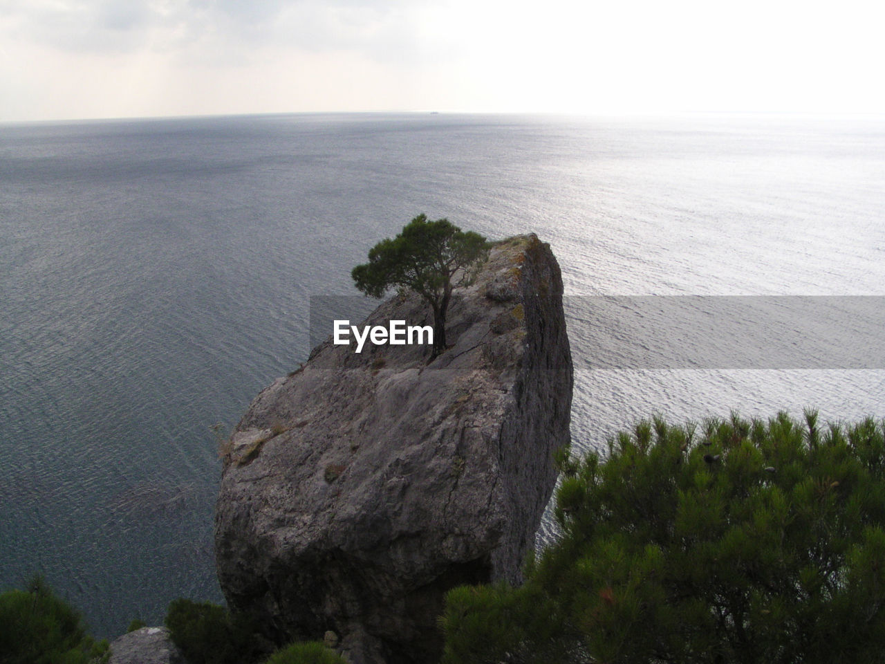 ROCK IN SEA AGAINST SKY