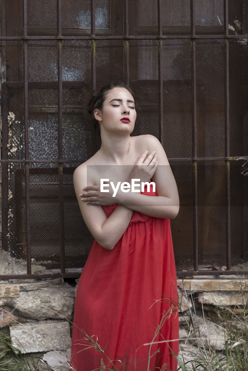 PORTRAIT OF A BEAUTIFUL YOUNG WOMAN STANDING OUTDOORS