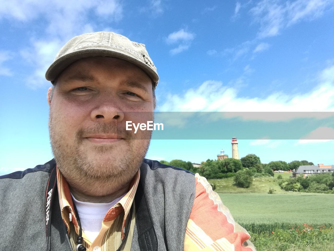 Portrait of man wearing cap on field against sky