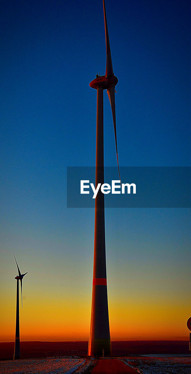 Low angle view of windmill against sky during sunset