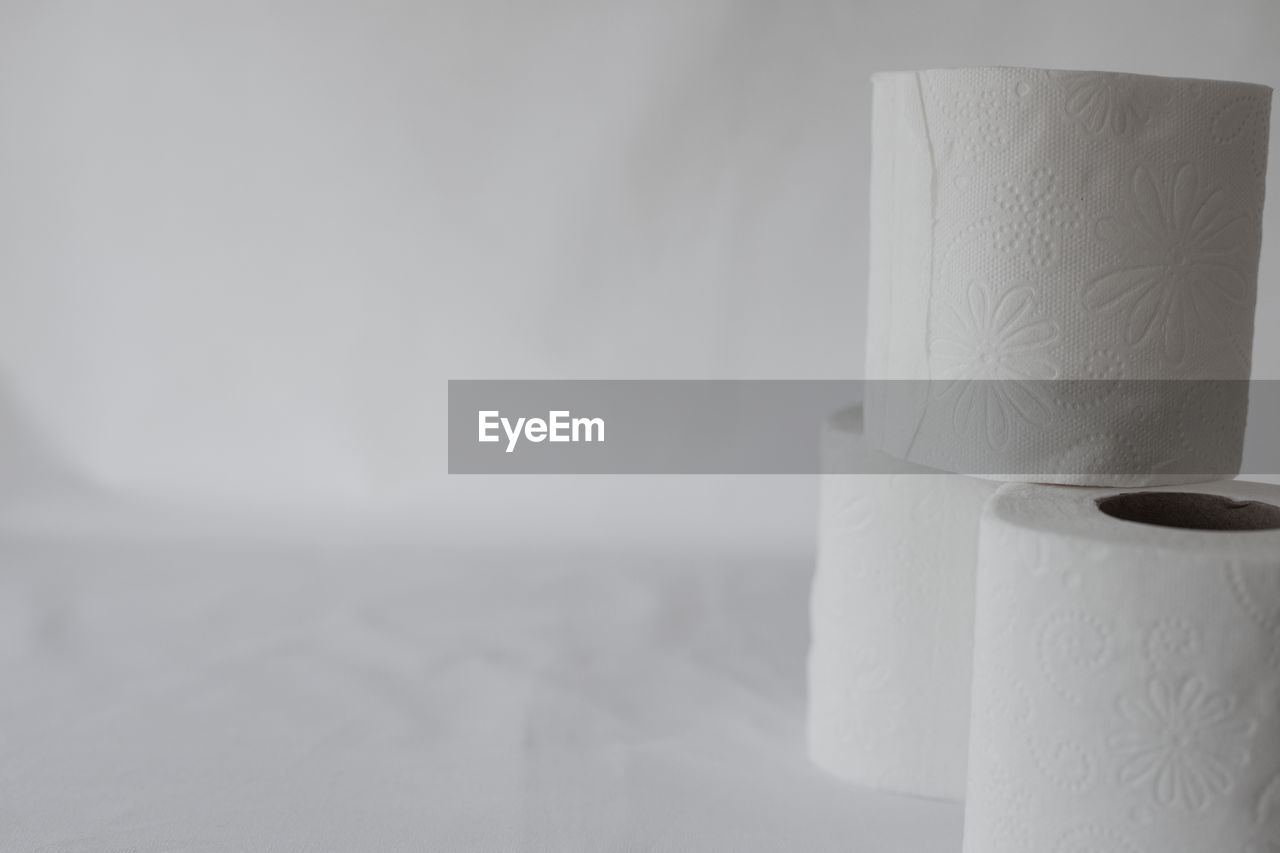 white, paper towel, toilet paper, indoors, paper, no people, vase, cylinder, copy space, rolled up, close-up, lighting, ceramic, simplicity, still life, studio shot, single object