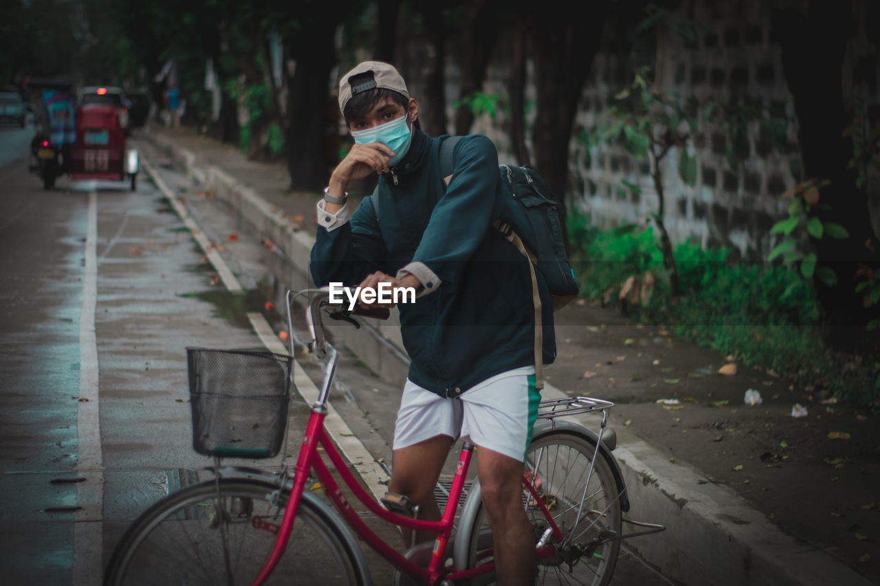 Rear view of man riding bicycle on street