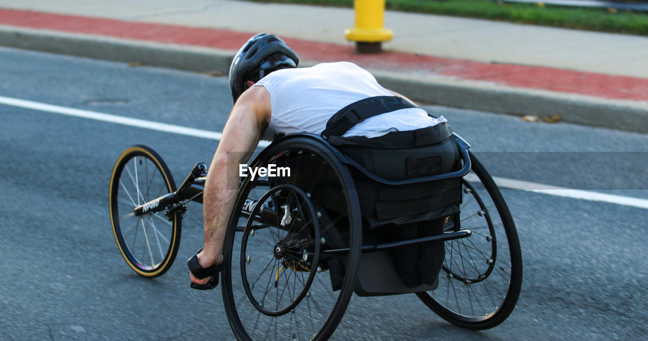 wheelchair, transportation, medical equipment, cycling, differing abilities, wheelchair racing, wheelchair sports, road cycling, sports, one person, bicycle, parasports, physical impairment, road, vehicle, city, street, road bicycle, endurance sports, adult, bicycle racing, mode of transportation, athlete, competition, full length, activity, wheel, land vehicle, physical injury, recumbent bicycle, day