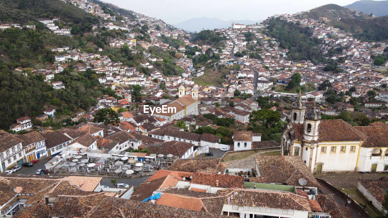 architecture, town, building exterior, built structure, building, city, village, residential district, house, high angle view, mountain, roof, nature, aerial photography, tree, community, no people, travel destinations, plant, environment, cityscape, land, landscape, day, outdoors, residential area, travel, neighbourhood, sky, tourism, scenics - nature, townscape, mountain range