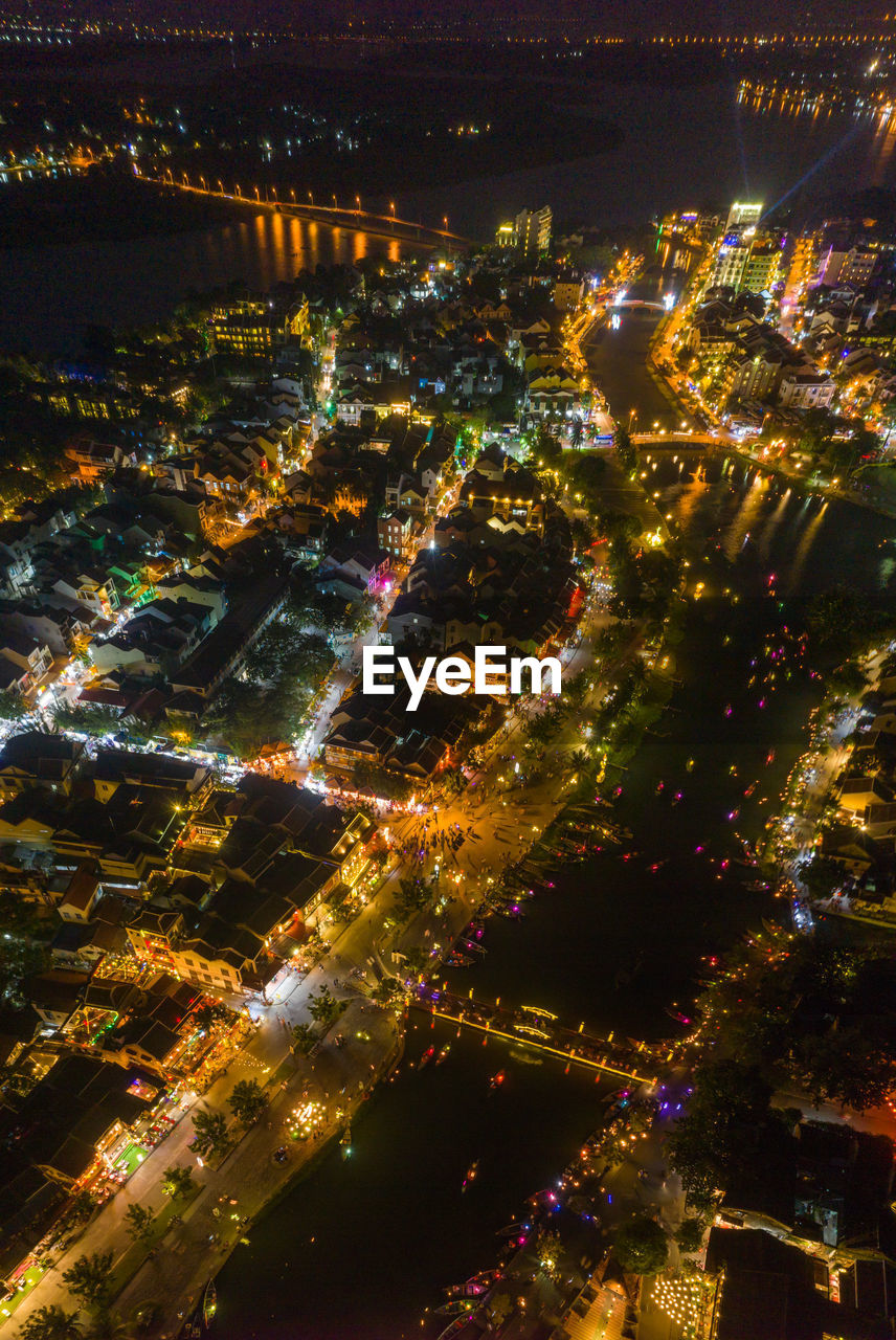 HIGH ANGLE VIEW OF ILLUMINATED CITY BUILDINGS AT NIGHT