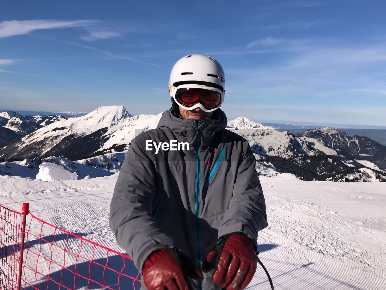 Man skiing on snow covered mountain against sky