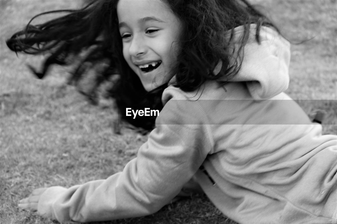 Happy girl playing on field at park