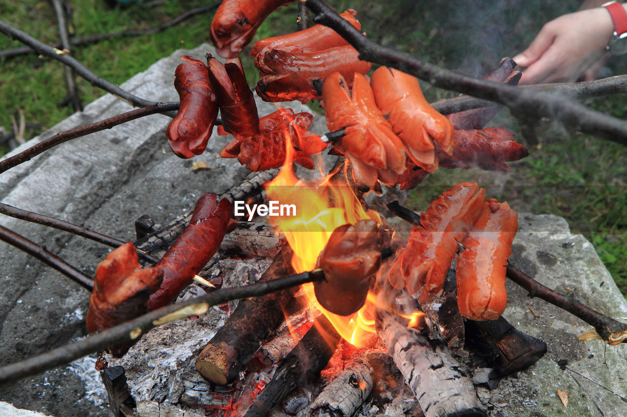 CLOSE-UP OF HANDS ON BARBECUE GRILL