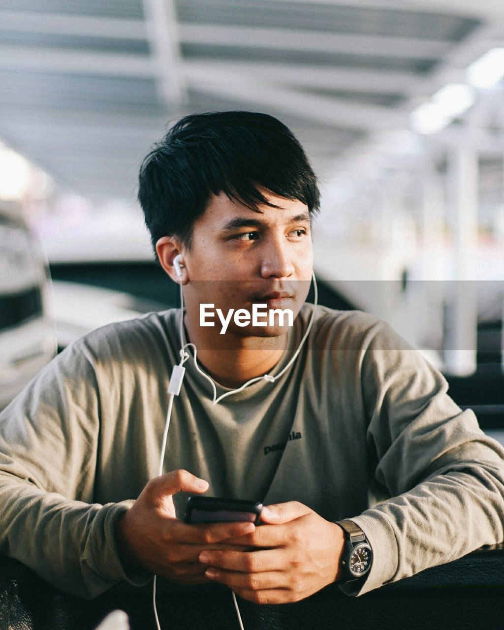 YOUNG MAN USING MOBILE PHONE IN OFFICE