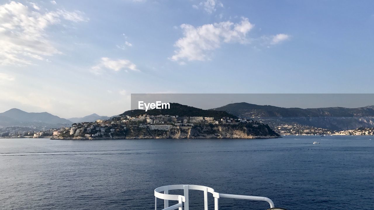 Scenic view of sea by mountains against sky