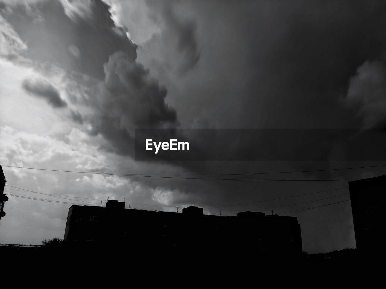 LOW ANGLE VIEW OF POWER LINES AGAINST CLOUDY SKY