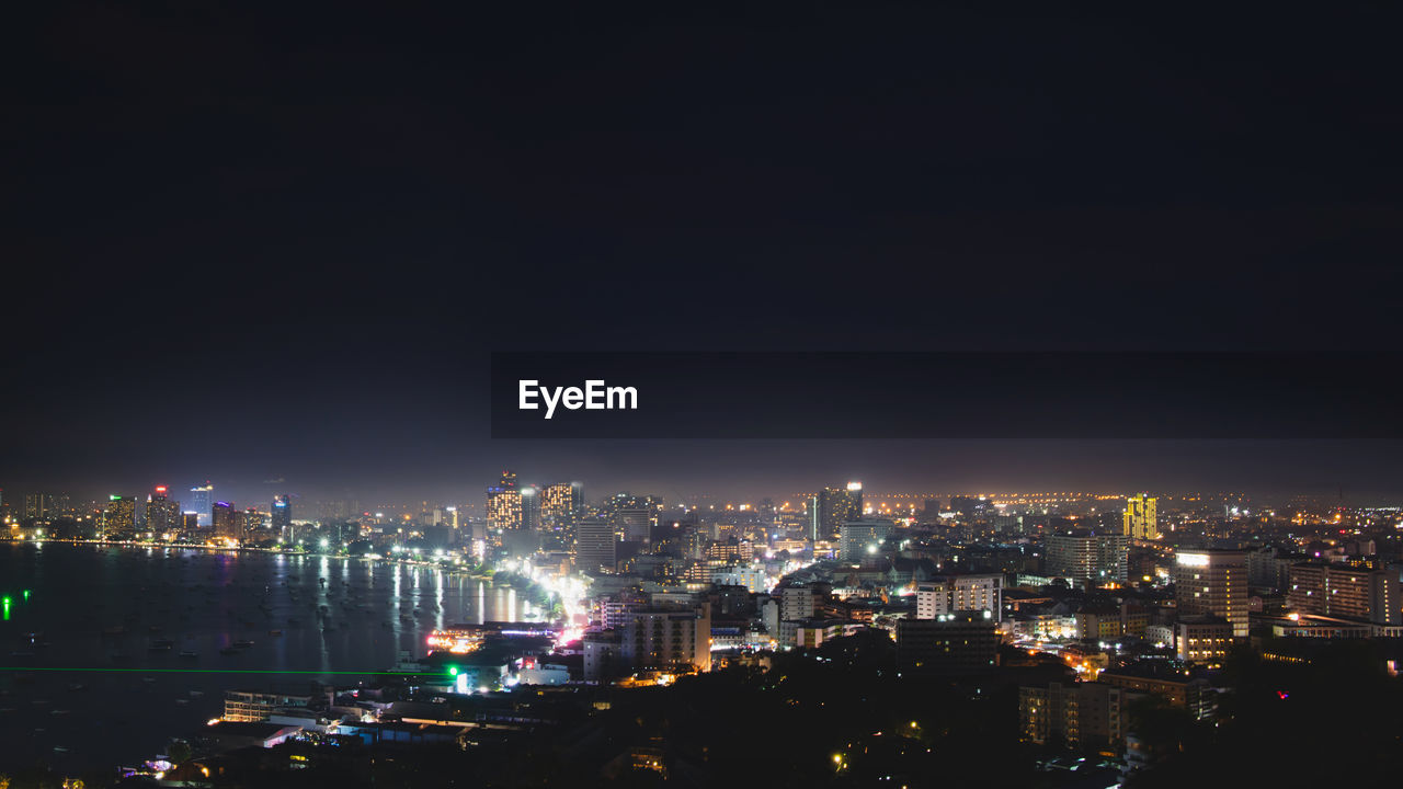 ILLUMINATED CITY BUILDINGS AGAINST SKY AT NIGHT