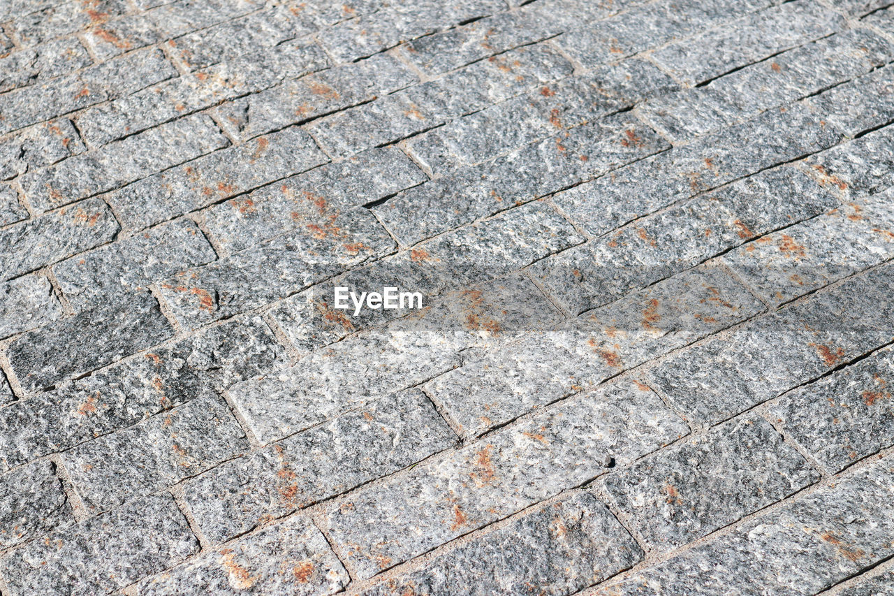 backgrounds, full frame, pattern, textured, road surface, no people, day, footpath, wall, soil, high angle view, cobblestone, floor, asphalt, rough, outdoors, gray, flooring, stone wall, close-up, brick, directly above, paving stone, architecture, street, rock