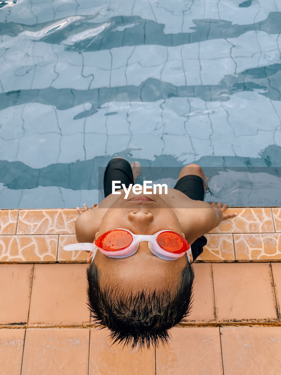 High angle view of man lying on swimming pool