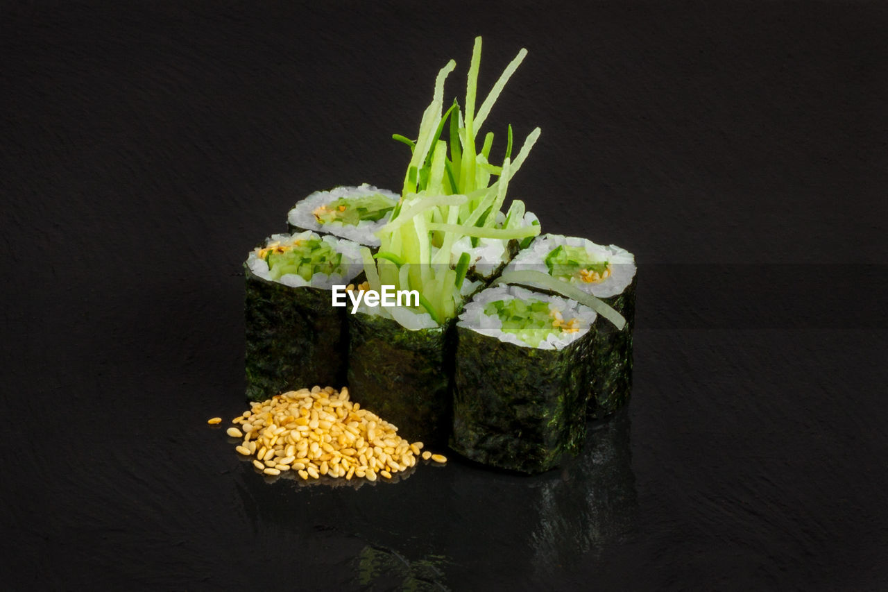 Close-up of sushi rolls over black background