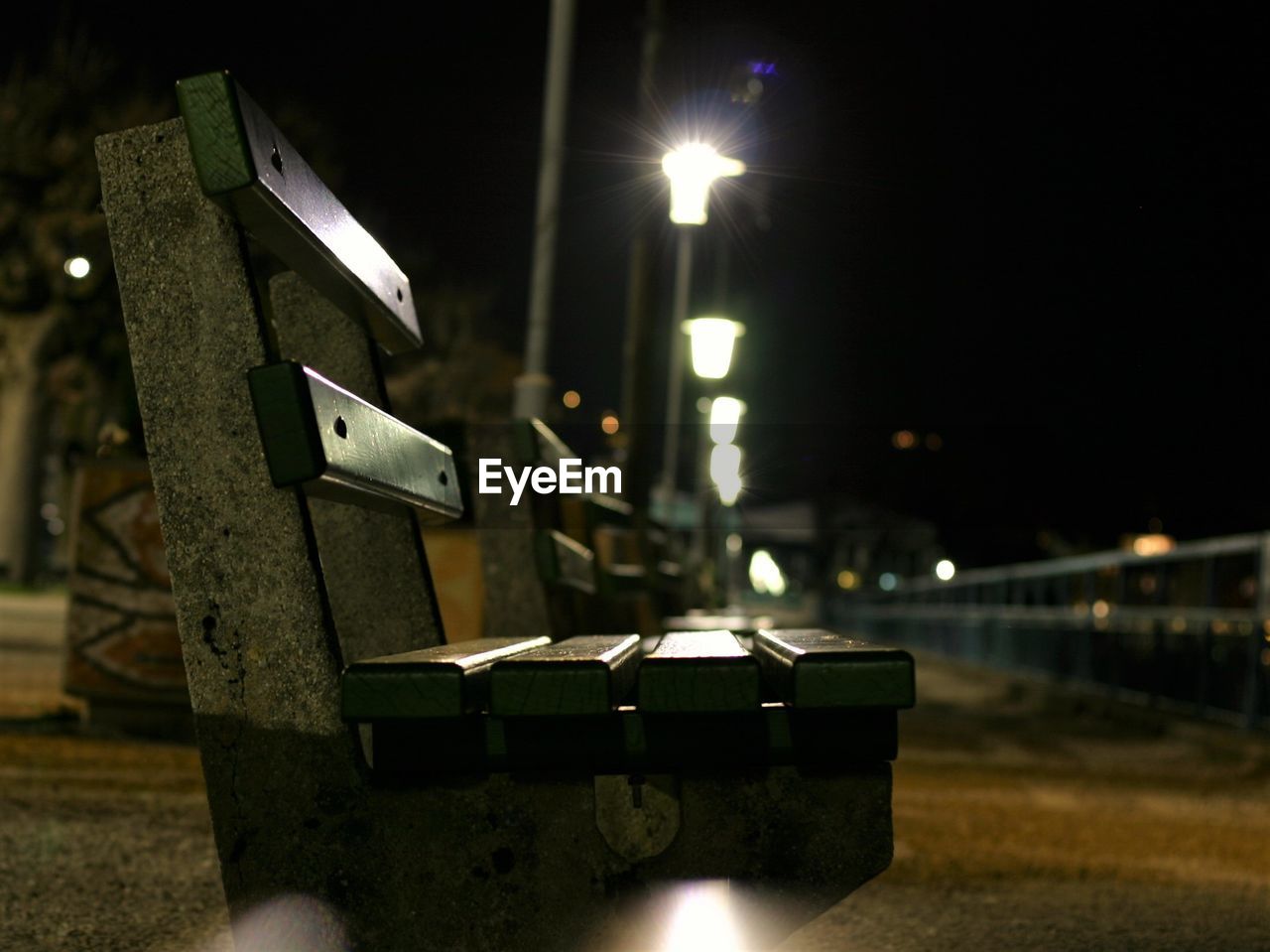 Close-up of illuminated empty bench at night