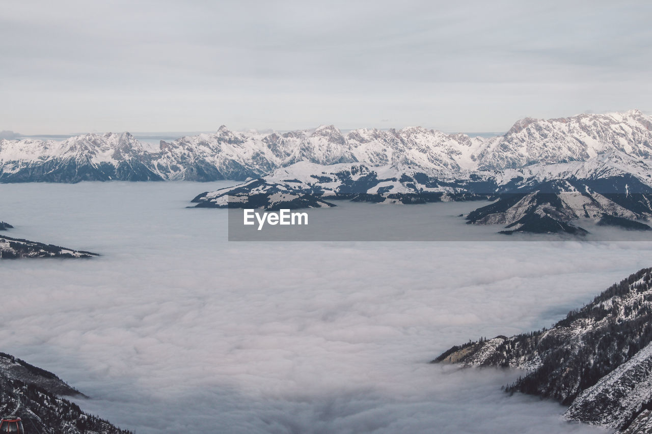 Scenic view of snowcapped mountains amidst clouds