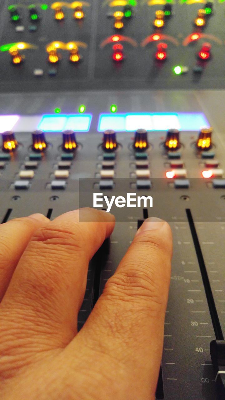 Close-up of human hand on illuminated panel