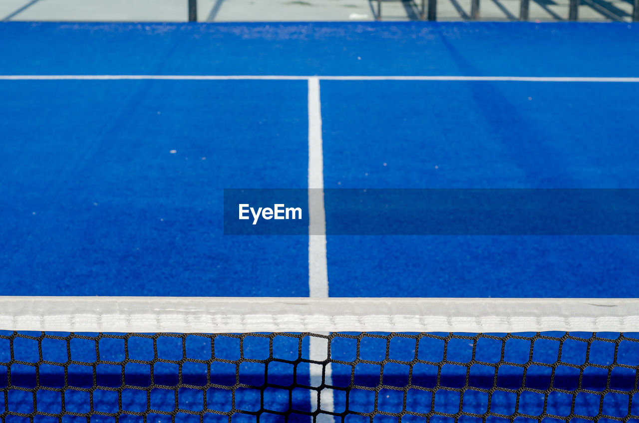 net, sports, tennis court, tennis, tennis net, sport venue, net - sports equipment, blue, absence, no people, day, empty, competition, high angle view, sports equipment, soccer-specific stadium, stadium, floor, outdoors, flooring, playing field, nature, baseball field, white