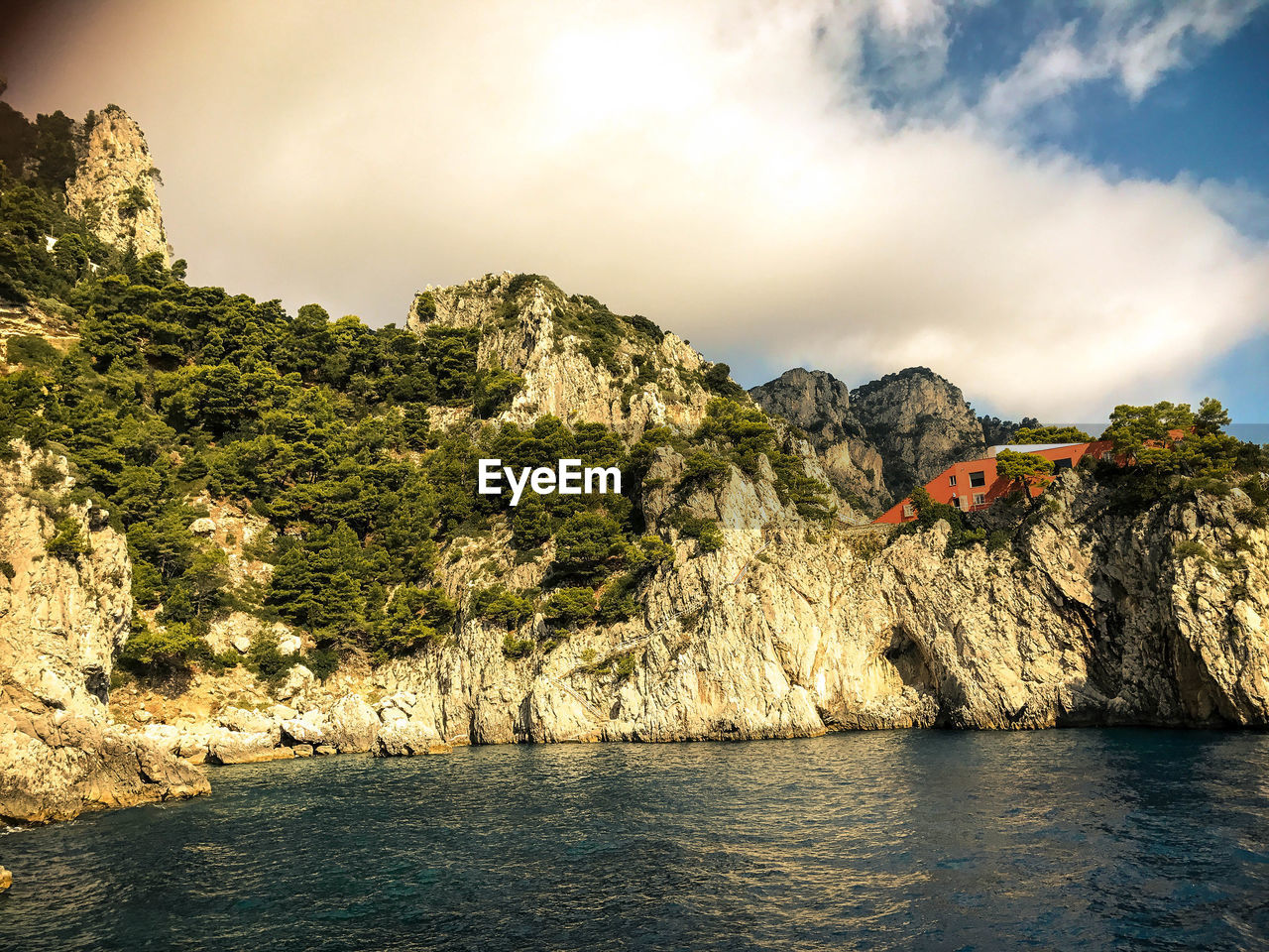 Scenic view of river and mountains against sky