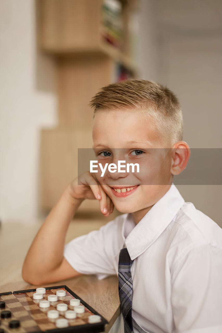 Portrait of boy playing board game at home