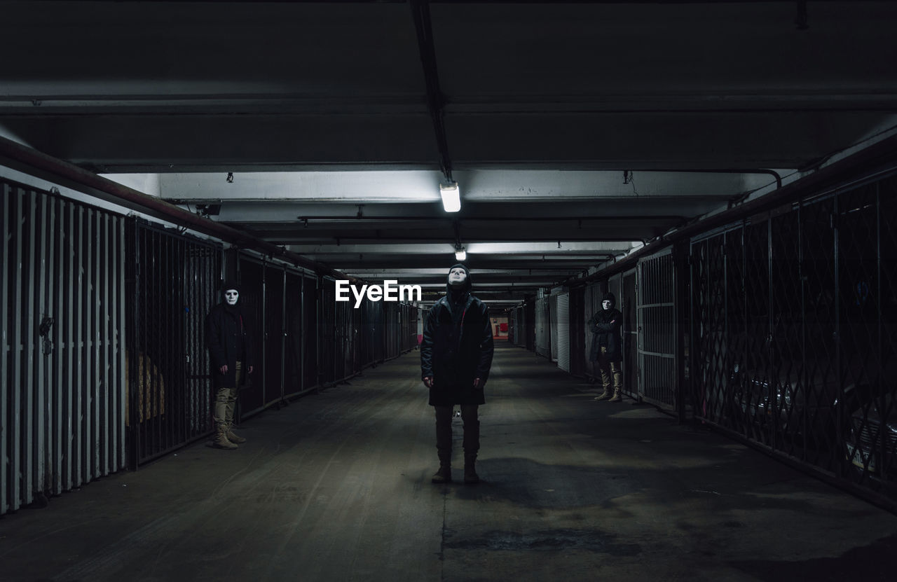 People with masks standing in garage