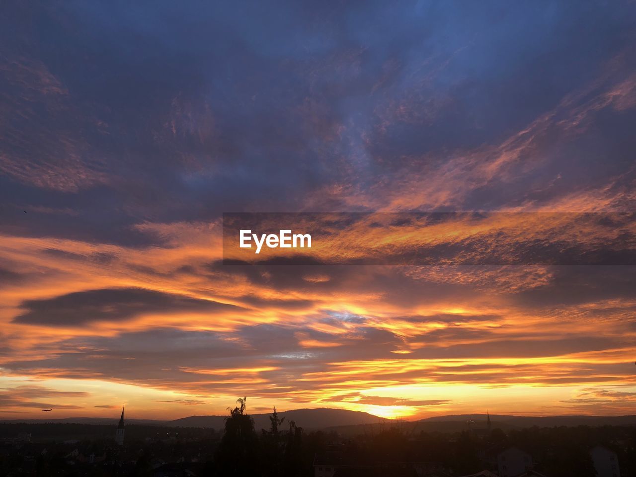 SCENIC VIEW OF SILHOUETTE LANDSCAPE AGAINST DRAMATIC SKY DURING SUNSET