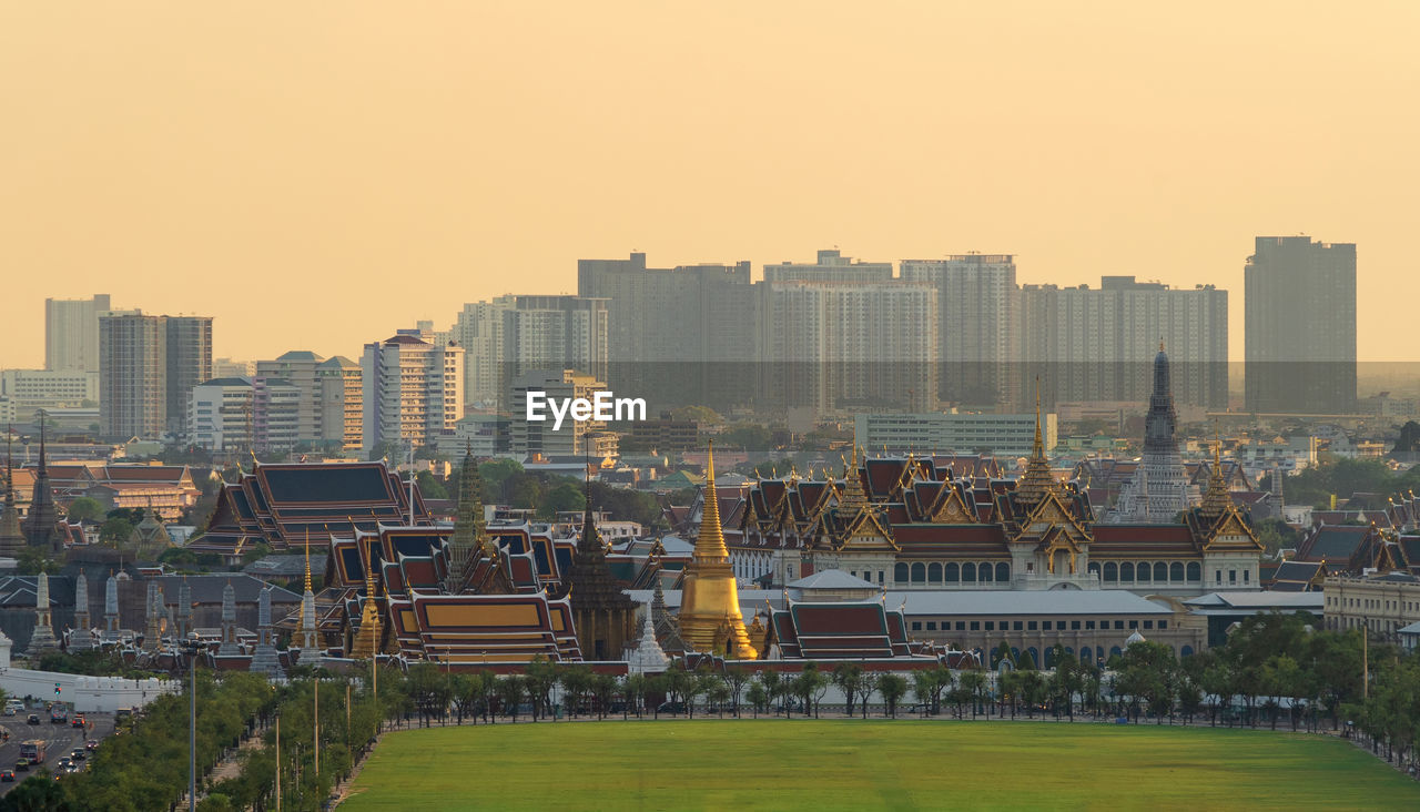 Buildings in city against clear sky during sunset