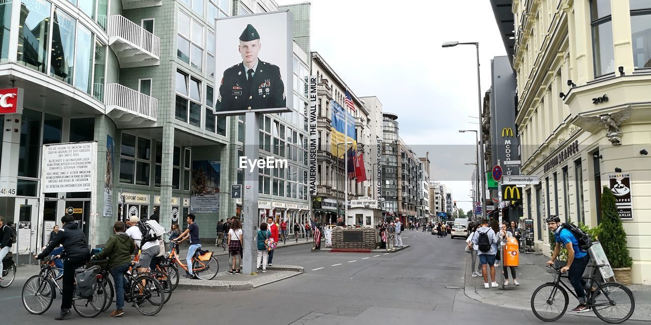 PEOPLE ON CITY STREET AGAINST BUILDINGS