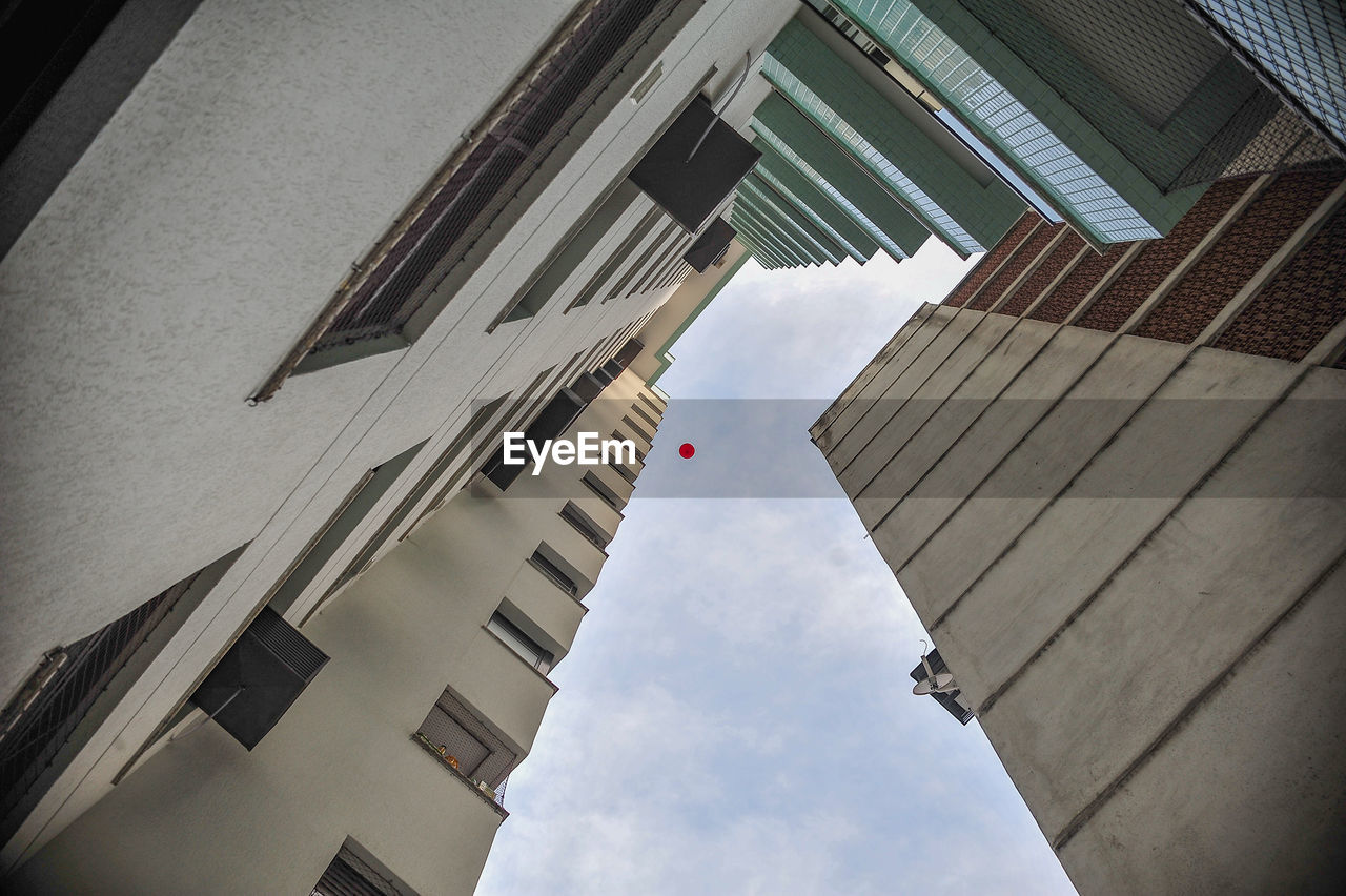 Low angle view of balloon amidst skyscrapers against sky