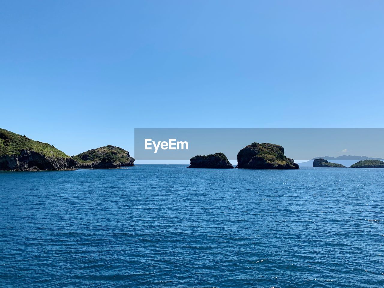 SCENIC VIEW OF ROCKS IN SEA AGAINST CLEAR SKY