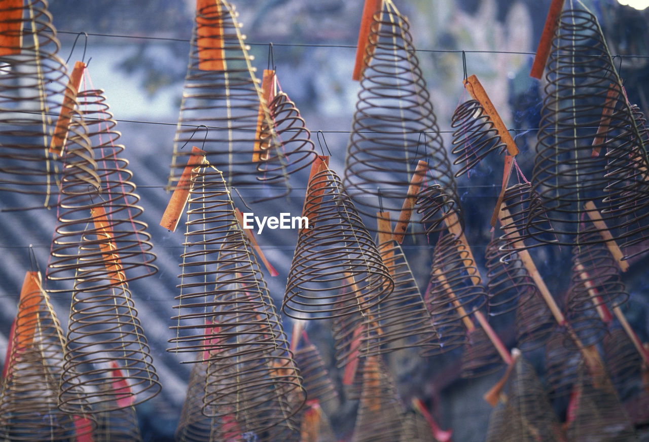 Low angle view of spiral incenses hanging at temple