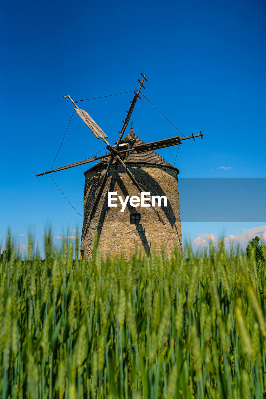 Traditional windmill on field against sky