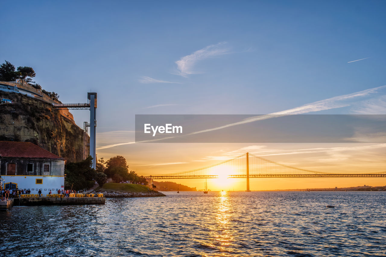 view of suspension bridge over river against sky during sunset