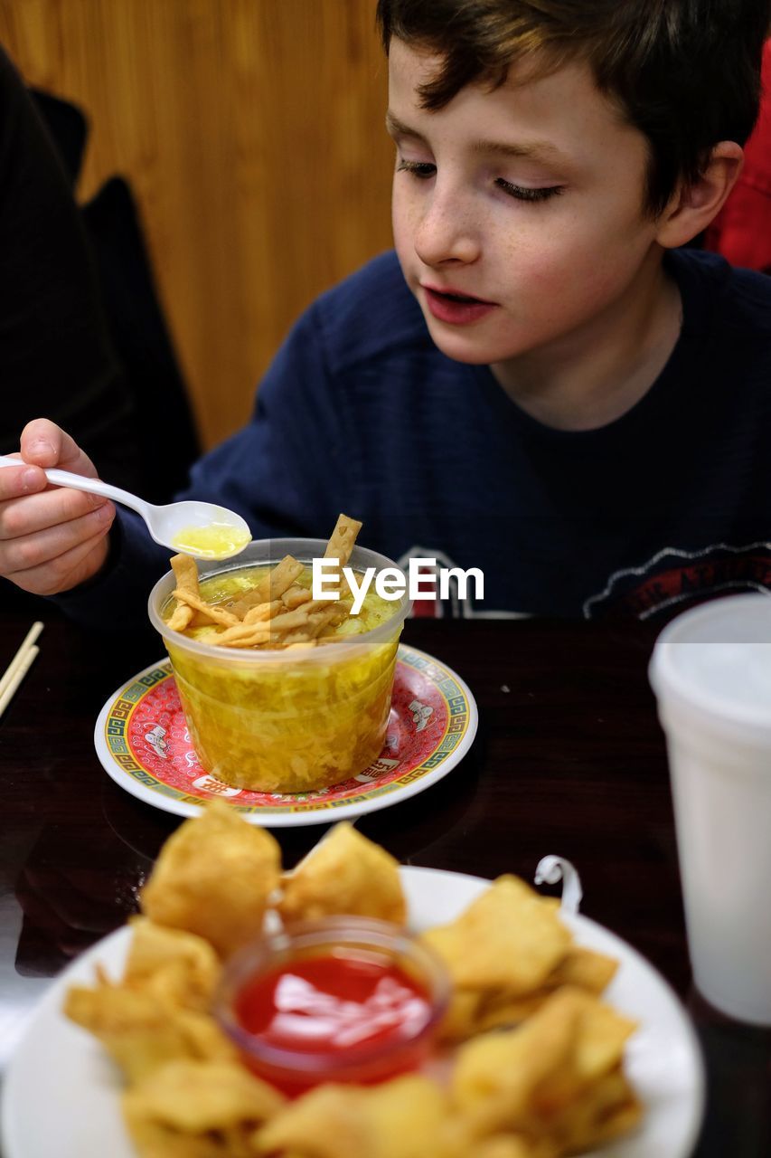 Boy having food at table