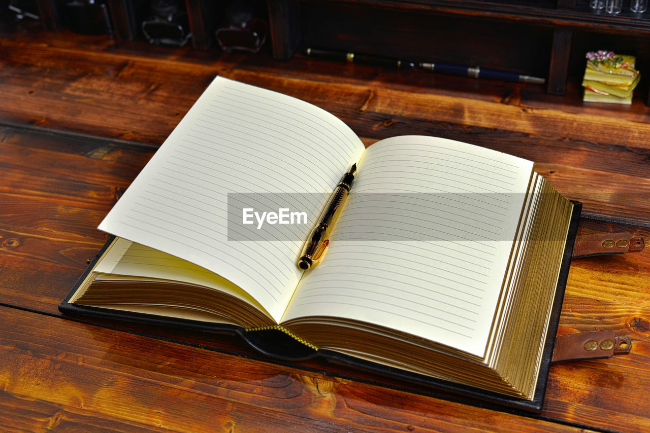 HIGH ANGLE VIEW OF BOOK ON TABLE