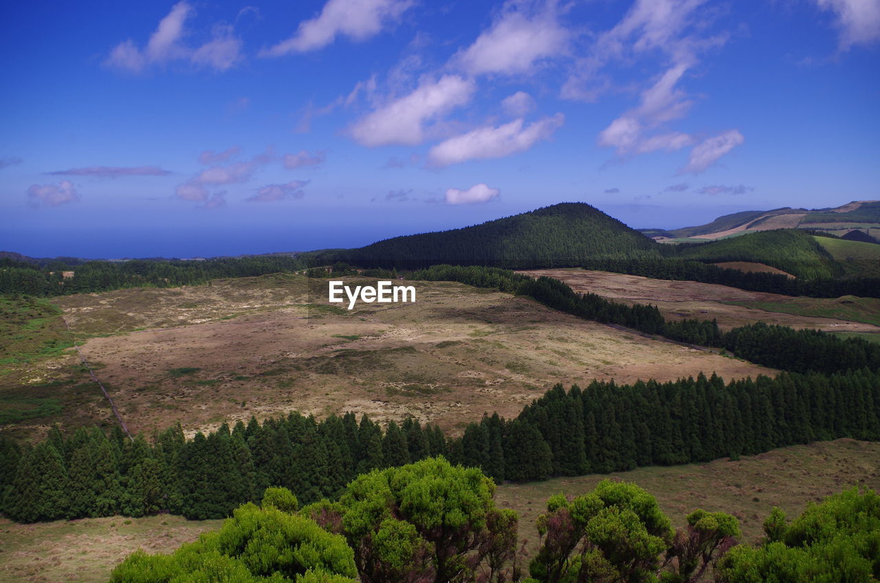 Scenic view of mountains against blue sky