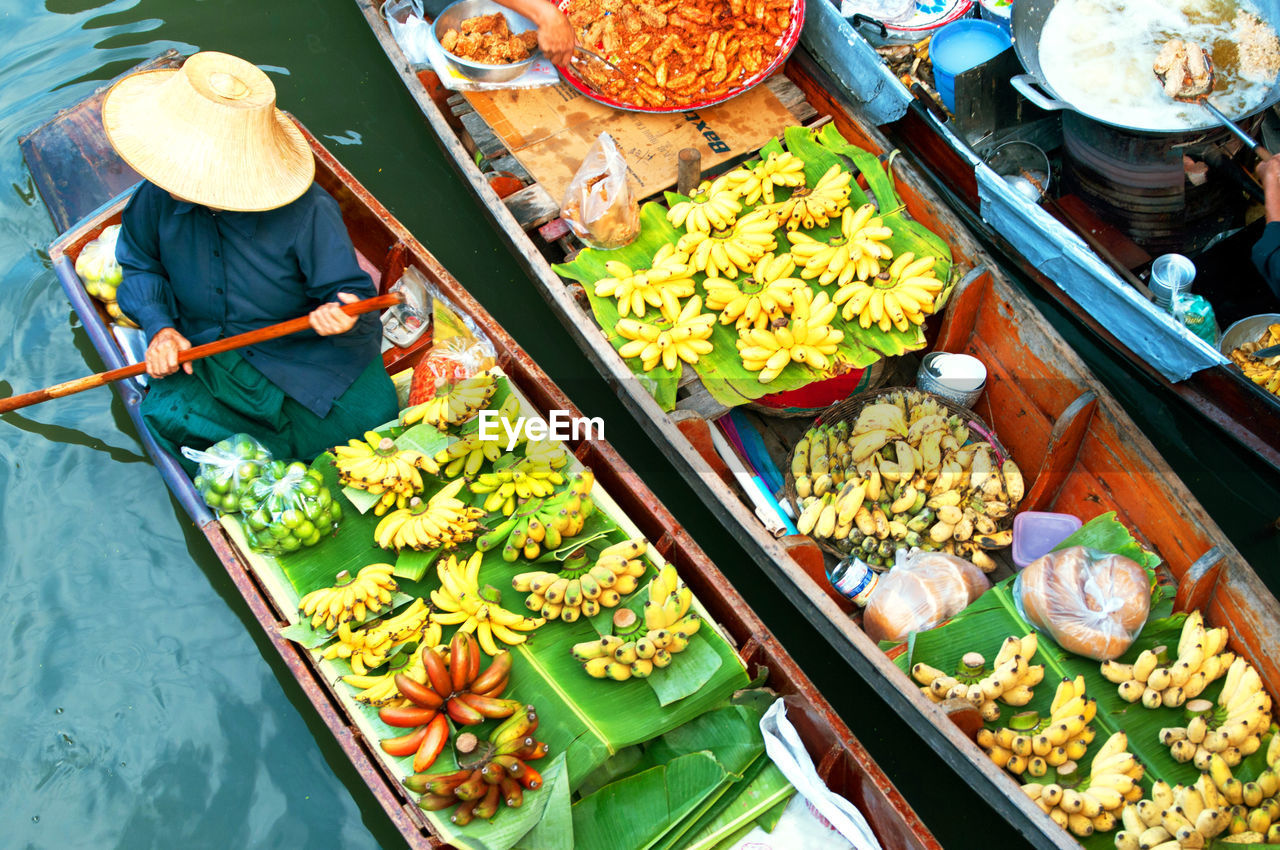 High angle view of woman with fruits on boat sailing in river