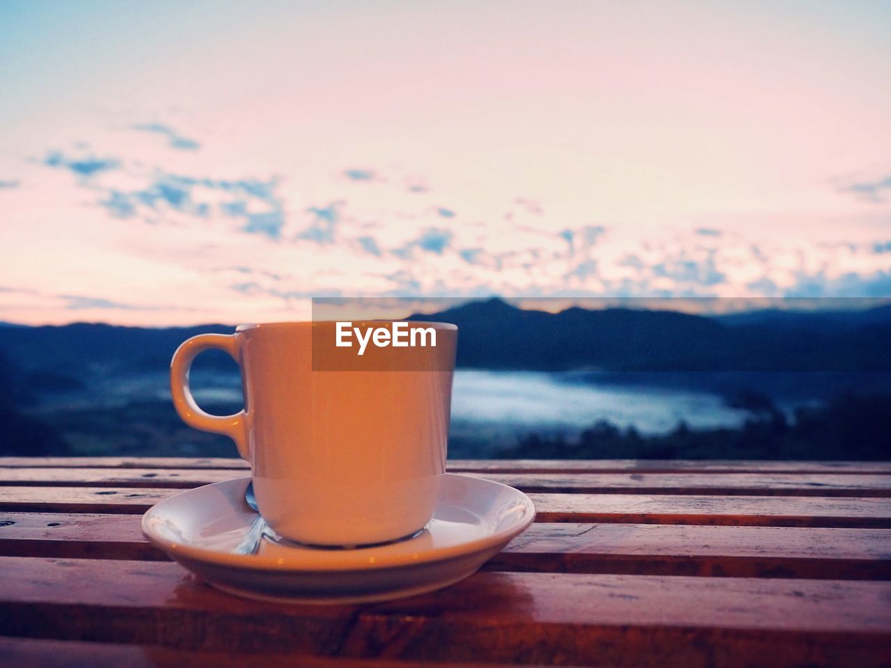 Close-up of coffee on table against sky during sunset