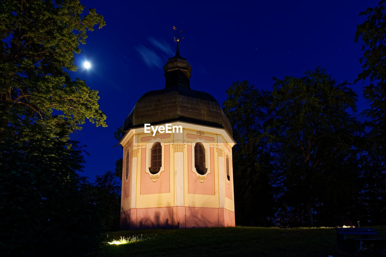 LOW ANGLE VIEW OF ILLUMINATED BUILDING AT NIGHT