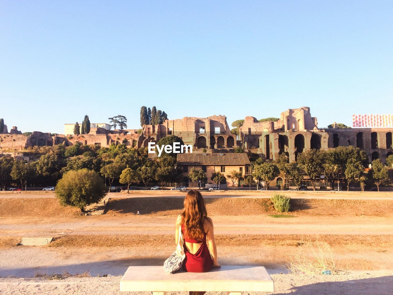 Woman overlooking ruined built structures