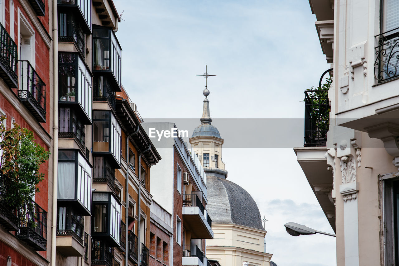 Low angle view of church and buildings in city against sky