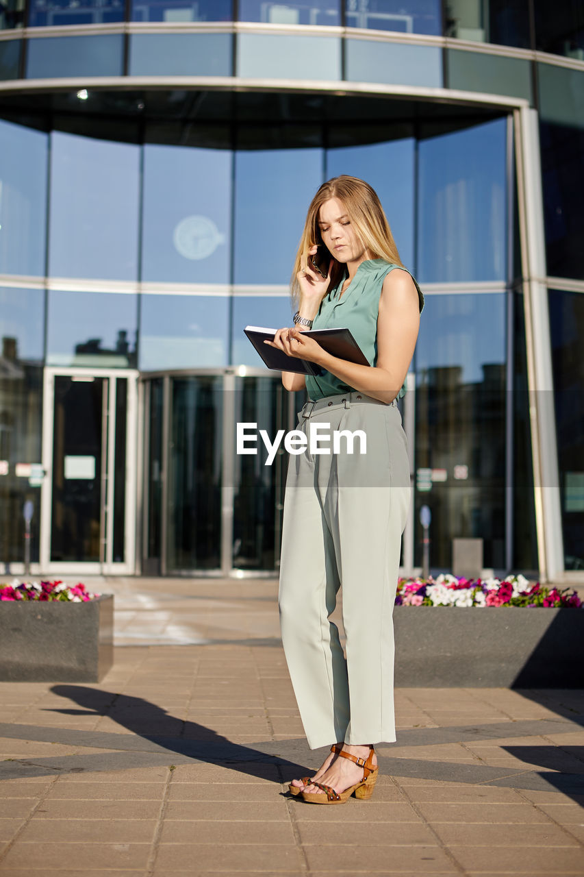 Woman talking on phone while standing on outdoors