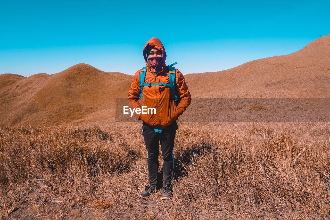 Portrait of man standing on land against mountains